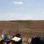 A landscape shows a plowed field and the top of a motorcycle..jpg